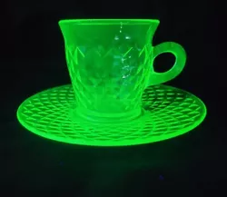 The round handle cup holds 8 oz and is made of green vaseline uranium glass. The set includes a cup and saucer in...