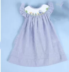 Pretty blue and white seersucker cotton with sweet bunny in a train embroidery on a smocked neckline. Pinstripe with...