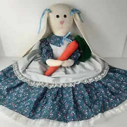 Hand sewn floppy eared Easter bunny decoration is off-white with blue floral dress and flat bottom base (no legs) to...