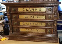 CLARKS SPOOL ORNATE CABINET 4-DRAWERS GOLD GLASS LABELS WITH ORIGINAL PULLS. MEASURES APPROXIMATELY 27” WIDE, 17”...