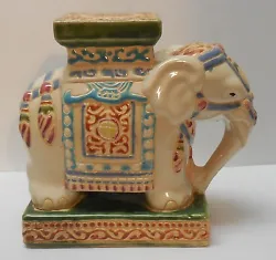 The elephant is an off white color with blue, green, mauve, and purplish blue colors. Approx 8