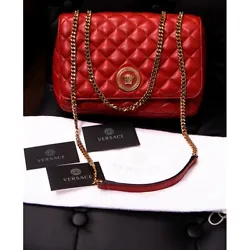Authentic Versace bag in a stunning classic style. Cherry red in a quilted lambskin leather. Gold tone hardware. Flap...