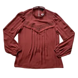 Ann Taylor pleated blouse. Fringe along that detailing as well. Pleated down the front. Brick red in color. Keyhole...