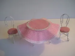 Well made with a combination of wood and white coated wire. Even has a removable/washable pink gingham/check table...
