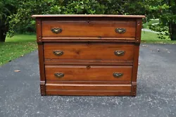 Three drawer chest or dresser with original brass pulls, carved details in the facia and paneled sides. Eastlake...