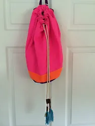 It is made out of canvas material. The inside is lined and has a zipper pocket. The outside is pink, orange, and...