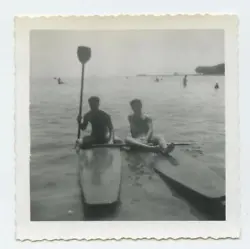 One man is holding a paddle. Photo is in overall good condition. Glossy surface.