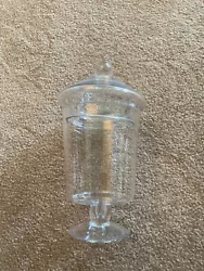 Clear glass apothecary with lid.  Approximately 10” tall.  6” in diameter at widest point.  Foot is...