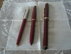 (2) Un stylo à bille ancien Parker. Il est de couleur grenat, son capuchon est argenté et doré. Le ressort est un...