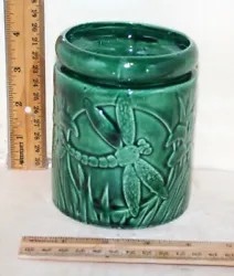 There is a dragonfly on two sides of the base (see pictures). This pot is a self-watering pot, just fill the bases with...