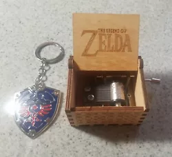 Handheld music box with The Legend of Zelda logo engraved under the lid. New and shiny Zelda keychain!
