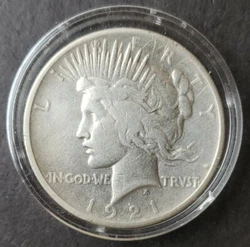 1921 $1 Peace Silver Dollar in a Capsule. Circulated. It was cleaned at some point and it has a number of scratches on...