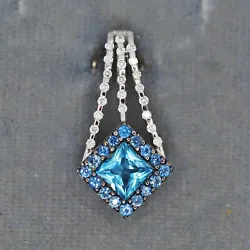Blue topaz surrounded by sapphires. 0.13 ctw Diamonds. 22.3 mm long. 11 mm wide.