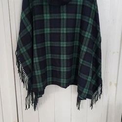 A stylish fringed poncho in our signature Black Watch plaid. Ribknit cowl neck. Time to cozy up.35% Polyester, 25%...