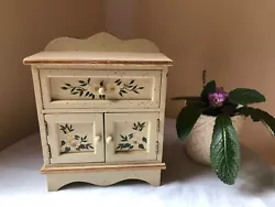 Pretty eggshell color with apple blossoms hand painted to the front. It has gold painted trim. In excellent condition....