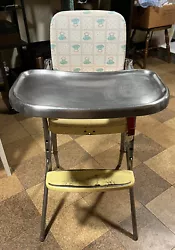 This vintage 1950’s-60’s Cosco folding high chair features a sturdy metal frame and removable tray & footrest. Seat...