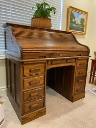 This antique roll top desk is made of solid oak and features a beautiful brown finish. With a height of 46 inches, a...