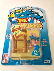 Very cute poseable Baby Smurf holding a baby bottle and her high chair. Still on card, unopened. The card has some...