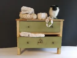 Super cute little dresser in a cream aged yellowed paint with green and a decal. Great little piece with paint wear and...