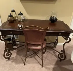 Vintage Writing Desk, 56X30. Leather inlay surrounded by solid wood also has 3 drawers. Legs are wrought iron. Desk is...