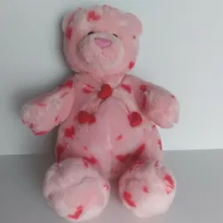 Gund Heads & Tales plush teddy bear in pink with red hearts has pink bow that crosses over belly with red heart pillows.