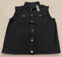 The vest is a classic denim trucker vest in black denim. It buttons down the front and has side pockets, flap pockets...