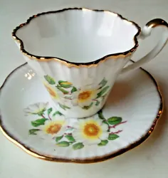 Bone china Salisbury pleated/scalloped edge cup and saucer with painted white roses with yellow centers, both saucer...