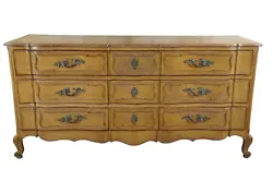 A stout mid century French Provincial dresser featuring serpentine form with nine dovetailed oakdrawers, paneled...
