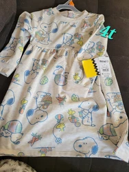 This charming dress features a delightful Easter theme with Peanuts character motifs. The colorful and playful design...
