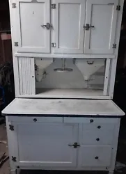 This antique Hoosier cabinet is a beautiful addition to any home. Crafted from wood and enamel, it features a white...