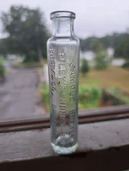 The mold is an early hing mold base.The antique aqua glass bottle holds 3 oz. and features blown-in mold details, an...