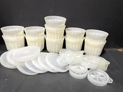 This vintage Tupperware set includes 10 small white cups with snap-on, airtight lids. The cups are shaped like jello...