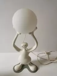 The iconic RUGG IO Smile table lamp. In the form of a smiling funny man holding a glowing ball over his head. There are...