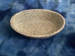 This very unique piece of ovenware is oval, 11 x 8 x 3 1/2”. The background is white with blue specs;mottling. There...