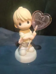 This adorable figurine from the Precious Moments collection features a young boy holding a heart shaped lollipop. The...
