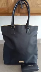 Large Versace Black Tote Bag has gold trim and gold metal Versace plate. 1 handle shows some peeling(see photos #7/8)...