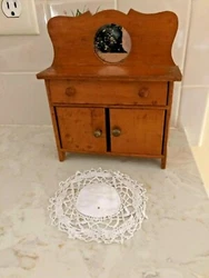 Could be a Salesmans Sample. From the early 1900s, I believe. Nice old doll dresser/wash stand with round mirror;....