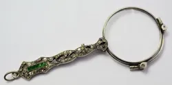 Silver eyeglass with openwork handle decorated with fake filigree and rhinestones. Art Deco period Probably...