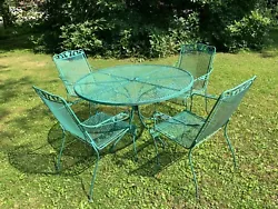 4 wrought iron chair with finely crafted foliage design on arms. All four chairs have arms. Very sturdy. Umbrella hole...