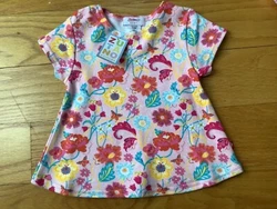 This cotton tee has two buttons on one shoulder for easy on and off.