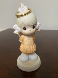 This beautiful porcelain figurine from 2001 depicts a little girl with a halo and outfit that says, 