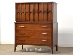 A mid century modern walnut tall dresser with brass drawer pulls and rosewood swooping pulls made by Kent Coffey...