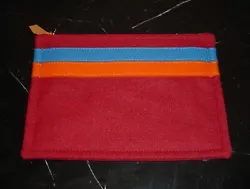 It is in wool in a colorways of Brick Red with an applied blue wool stripe. It is in excellent condition with no signs...