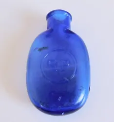 Either a pill bottle or a pocket flask. Cobalt Blue Glass. embossed 