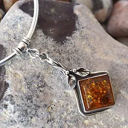 This amazing necklace is made up of a square shaped, bezel set honey amber stone that is incorporated with an artsy...
