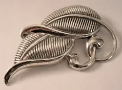 This sterling silver pin has the type of stylized tropical leaves I used to see on 1950s bark cloth patterns. It has a...