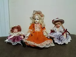 3 Very collectable vintage ceramic small girl dolls with blonde hair, gorgeous old style red dress and hat . Excellent...