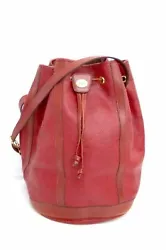 The bag features an adjustable red leather strap, allowing it to be worn as a cross-body or shoulder bag. The bag opens...