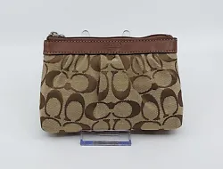 This pretty signature pouch wristlet from Coach is in very good used condition with mild preowned wear.