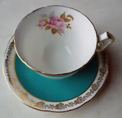 Aynseley cup and saucer. Turquoise and Gold Trim, gold and pink roses inside footed cup. Scalloped edges. Saucer approx.